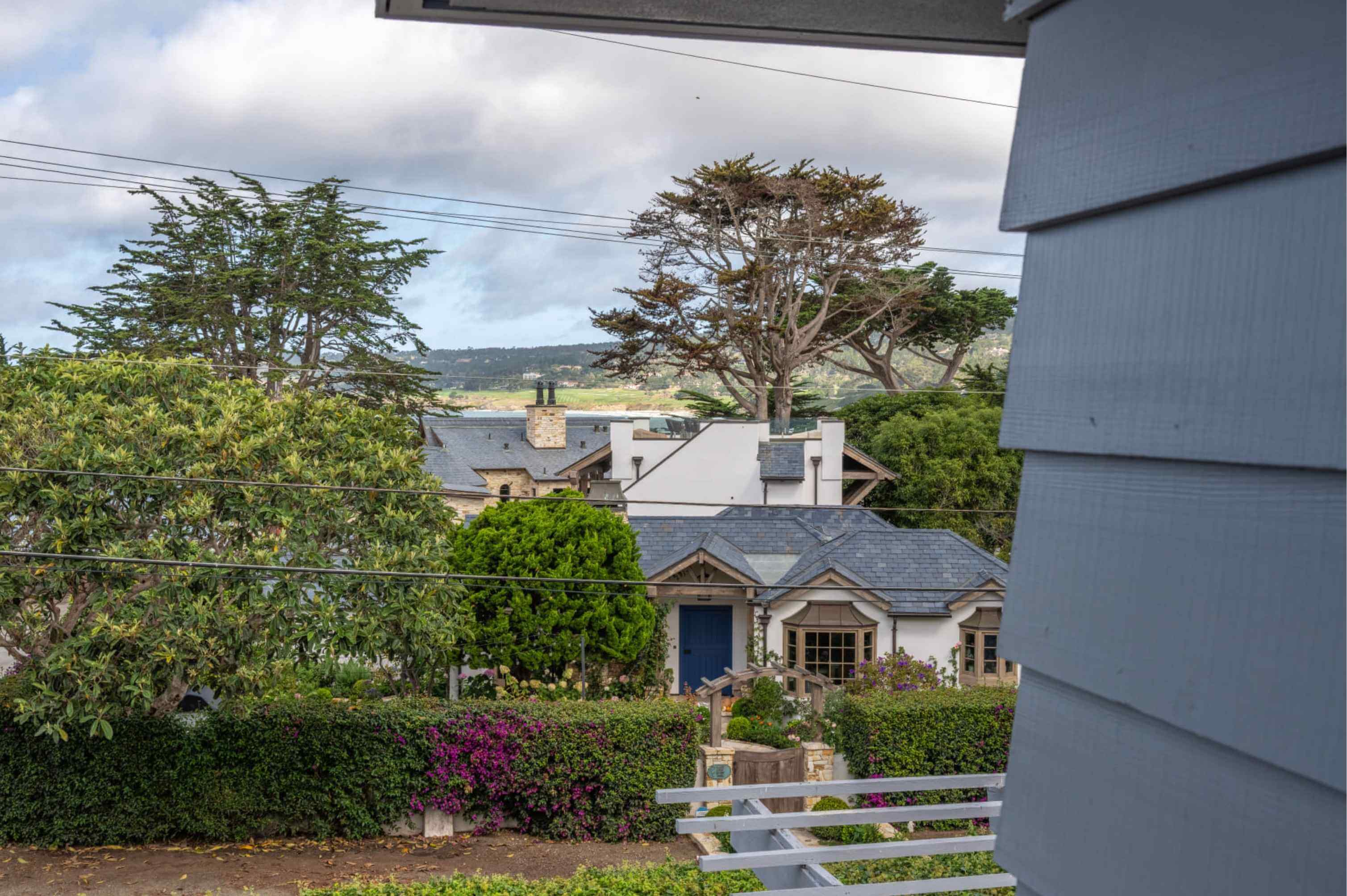 Carmel cottage surrounded by cypress trees near the Pacific Ocean coastline