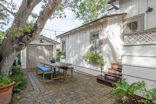 Side patio area showing the exterior architectural details and landscaping of the renovated home.
