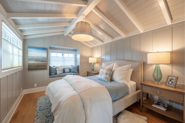 Gracious guest bedroom featuring a cozy window seat and vaulted ceilings in Carmel real estate.