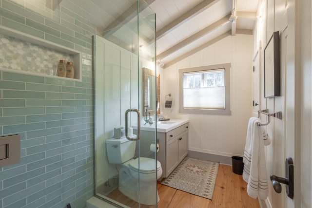 Meticulously renovated bathroom featuring a glass shower enclosure and custom tile work.
