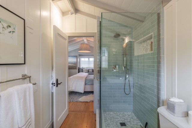 Luxury bathroom showing the walk-in glass shower and seamless flow into the adjoining bedroom.