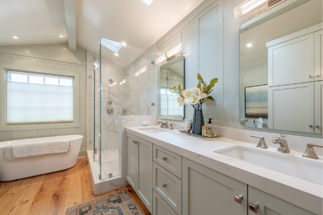 Meticulously renovated primary bathroom with freestanding tub and double vanity in Golden Rectangle real estate.