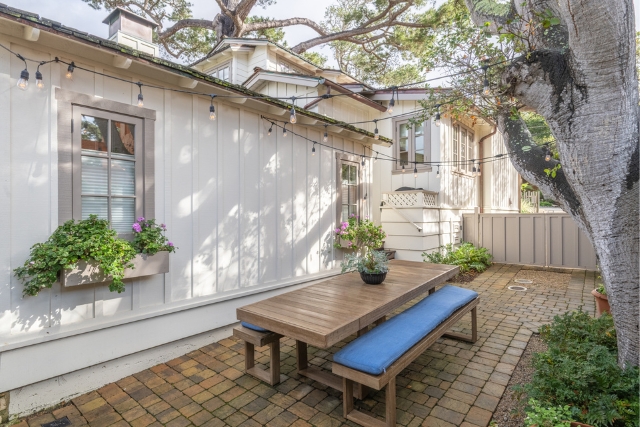 Private finished backyard featuring an outdoor dining area and string lights in Carmel-by-the-Sea.